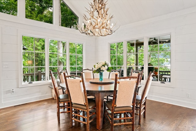 dining room featuring visible vents, a healthy amount of sunlight, an inviting chandelier, and dark wood-style flooring