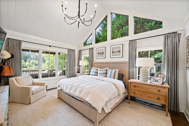 bedroom featuring a notable chandelier, multiple windows, wood finished floors, and high vaulted ceiling