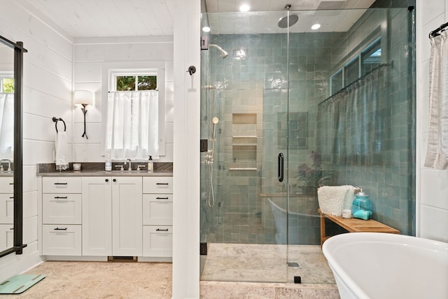 bathroom featuring a freestanding tub, a stall shower, and vanity