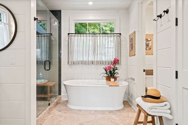 full bathroom featuring a freestanding tub, recessed lighting, a stall shower, tile walls, and tile patterned floors