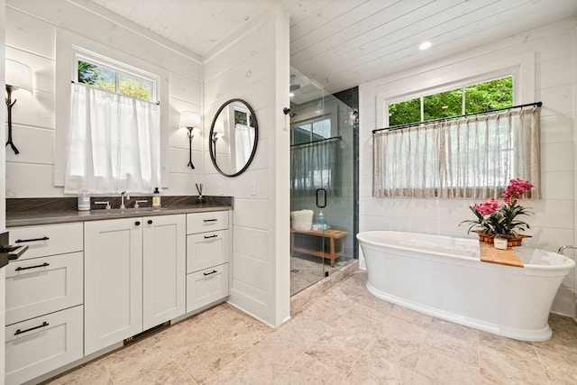 full bathroom featuring vanity, a healthy amount of sunlight, a shower stall, and a freestanding bath