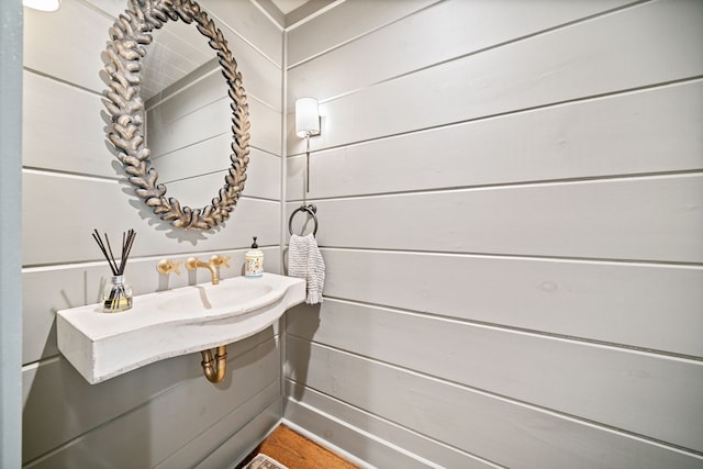 bathroom with wooden walls and a sink