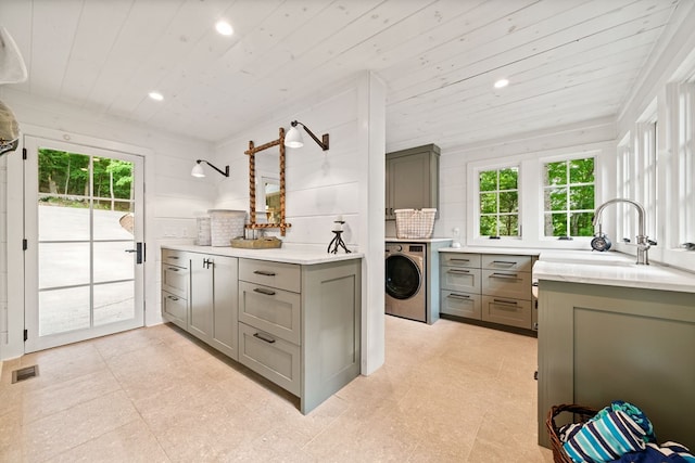 kitchen with visible vents, gray cabinets, light countertops, washer / dryer, and wood ceiling