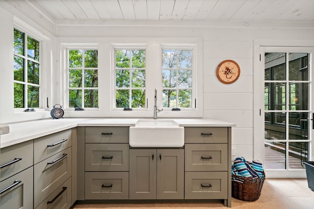 kitchen with a sink, gray cabinetry, wooden ceiling, and light countertops