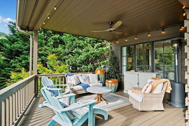 wooden deck with an outdoor hangout area and ceiling fan