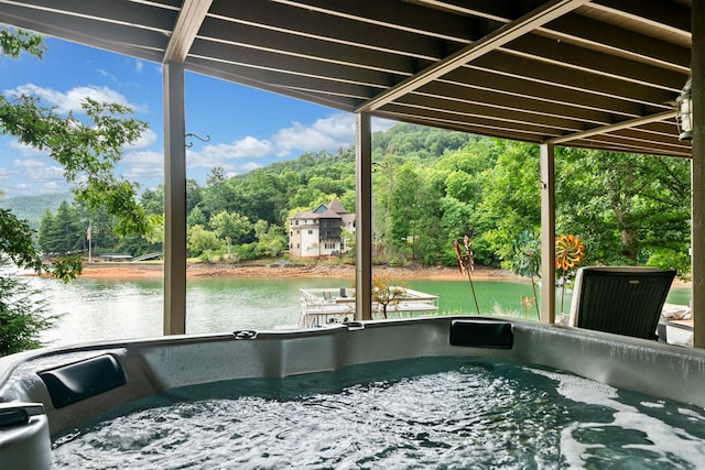 exterior space with a water view and a hot tub