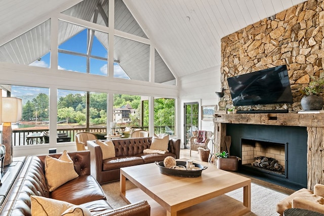 living area featuring high vaulted ceiling, a large fireplace, and wood finished floors