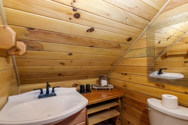 bathroom featuring sink, wood ceiling, wooden walls, and toilet