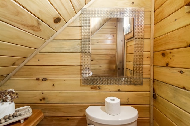 bathroom with toilet and wooden walls