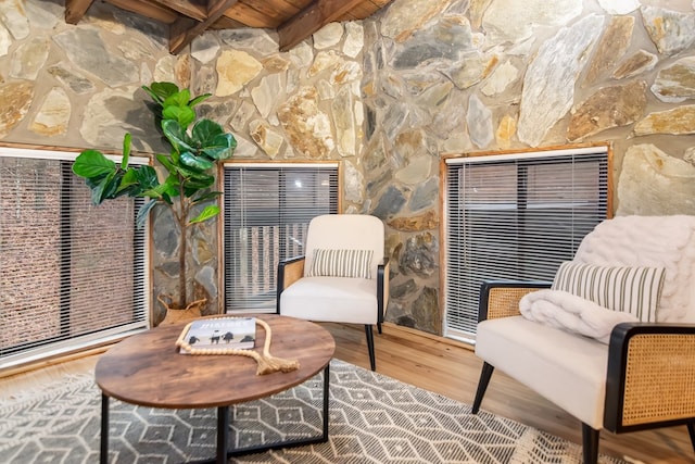 living area with wood ceiling, wood-type flooring, and beam ceiling