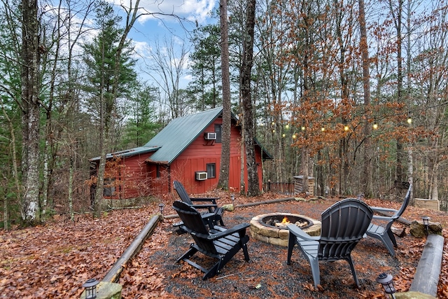 view of yard featuring cooling unit, a wall mounted air conditioner, and a fire pit