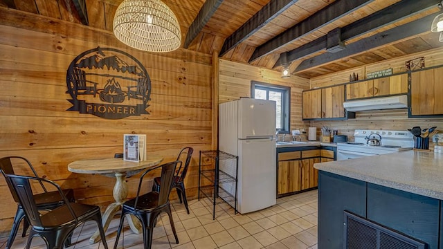 kitchen with beamed ceiling, white appliances, wooden walls, and wooden ceiling