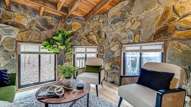 living area featuring wood-type flooring, plenty of natural light, wooden ceiling, and beam ceiling