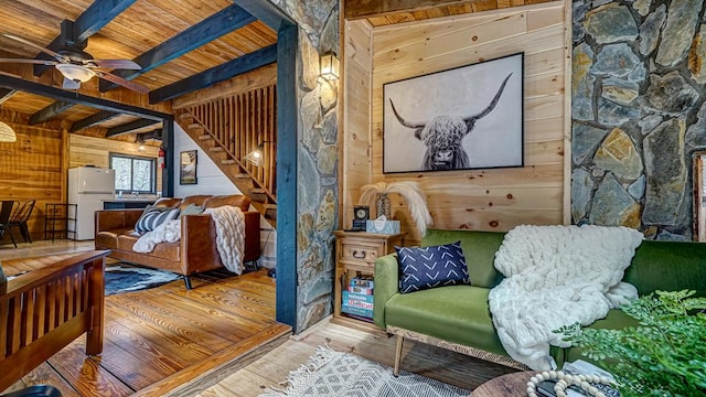 living area with wood ceiling, ceiling fan, beam ceiling, wood-type flooring, and wood walls