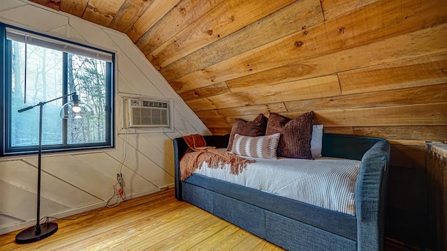 unfurnished bedroom featuring hardwood / wood-style flooring, lofted ceiling, a wall unit AC, and wooden ceiling