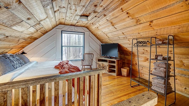 bedroom with lofted ceiling, hardwood / wood-style floors, wooden walls, and wooden ceiling