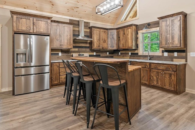 241 Lemmon Ln, Ellijay, GA 30540 - kitchen with stainless steel fridge, wall chimney exhaust hood, a center island, vaulted ceiling, and light wood-style floors