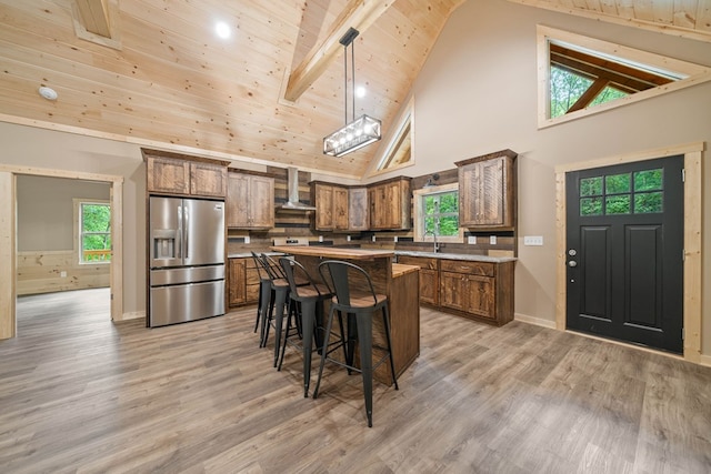 241 Lemmon Ln, Ellijay, GA 30540 - kitchen featuring stainless steel fridge with ice dispenser, wall chimney exhaust hood, a breakfast bar, high vaulted ceiling, and a kitchen island