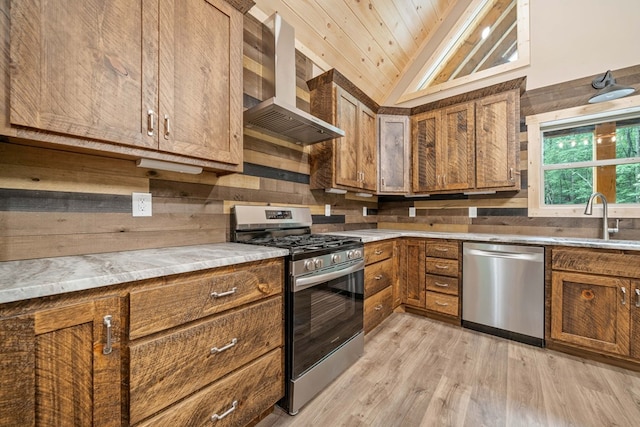 241 Lemmon Ln, Ellijay, GA 30540 - kitchen featuring appliances with stainless steel finishes, wall chimney range hood, lofted ceiling, brown cabinets, and light wood-style floors