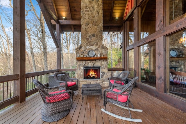 wooden terrace featuring an outdoor stone fireplace