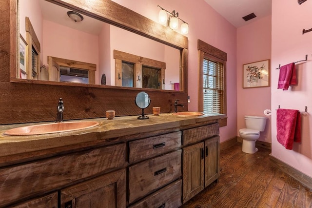 bathroom featuring backsplash, vanity, wood-type flooring, and toilet