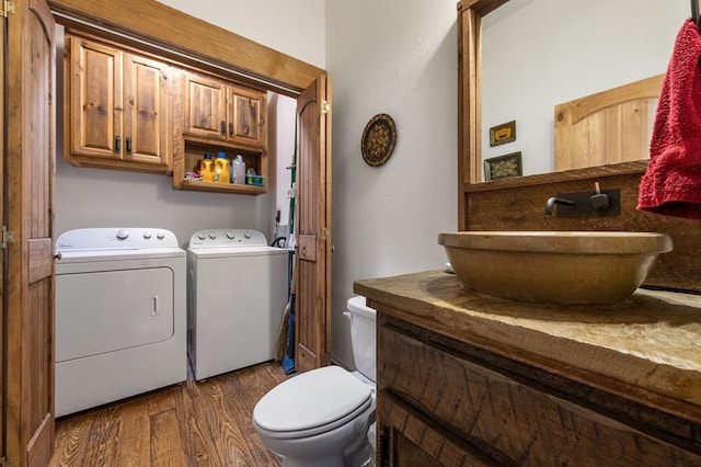 bathroom with separate washer and dryer, toilet, vanity, and hardwood / wood-style flooring