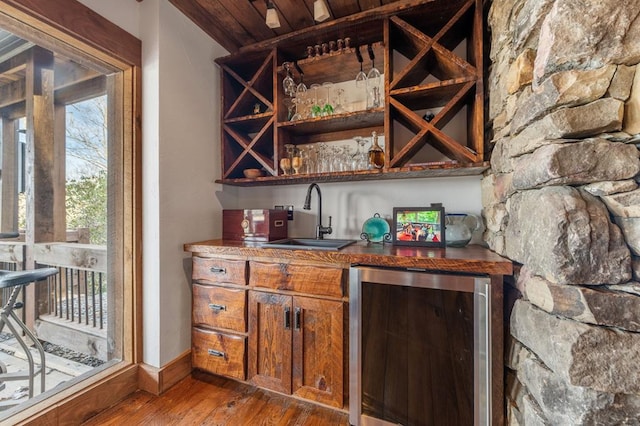 bar featuring sink, wooden ceiling, hardwood / wood-style floors, wine cooler, and stainless steel refrigerator