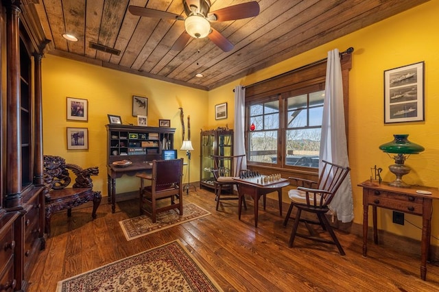 living area featuring ceiling fan, dark hardwood / wood-style flooring, wood ceiling, and ornamental molding