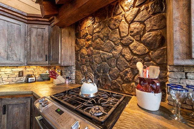 kitchen featuring wood counters, dark brown cabinetry, and stainless steel range with gas cooktop