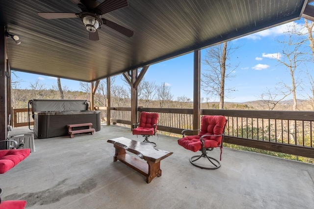 view of patio with ceiling fan and a hot tub