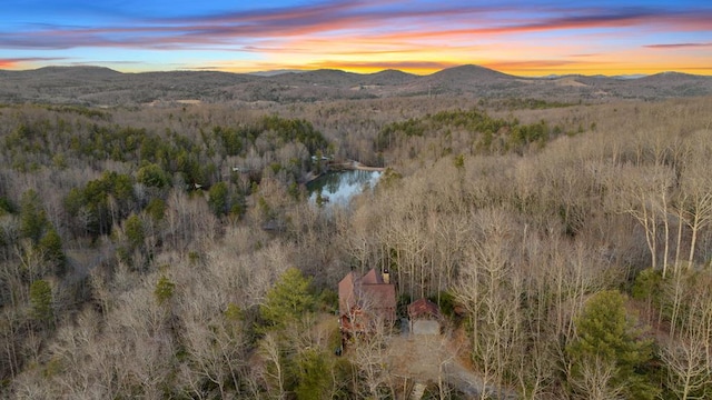 aerial view at dusk with a forest view and a water and mountain view