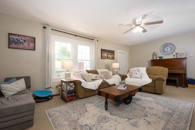 carpeted living room with ceiling fan and a textured ceiling