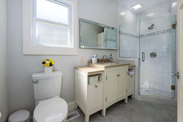 bathroom featuring vanity, toilet, tile patterned floors, and a shower with shower door