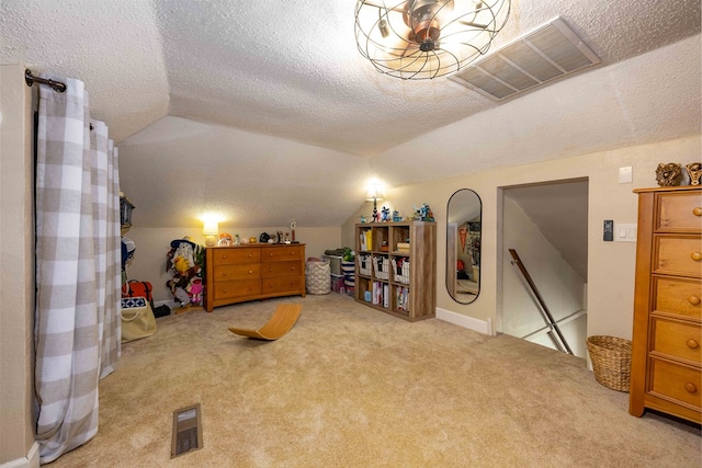 carpeted bedroom featuring a textured ceiling and lofted ceiling