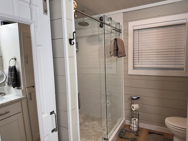 bathroom featuring vanity, toilet, and a shower with door