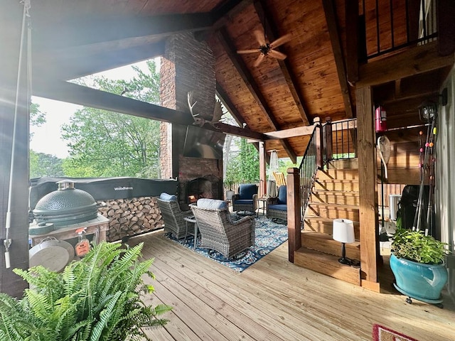 wooden deck with ceiling fan and an outdoor living space with a fireplace