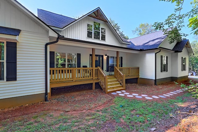 view of front of home featuring board and batten siding, covered porch, and a shingled roof