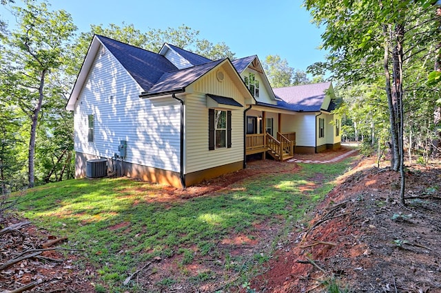 rear view of property with cooling unit and a lawn