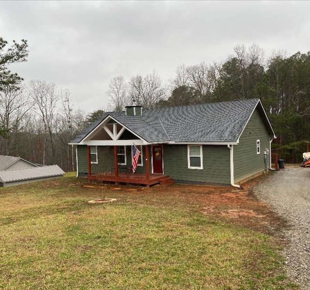 view of front of property featuring a front lawn and roof with shingles