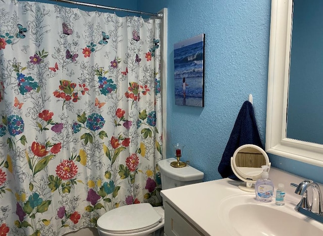 bathroom featuring vanity, toilet, and walk in shower