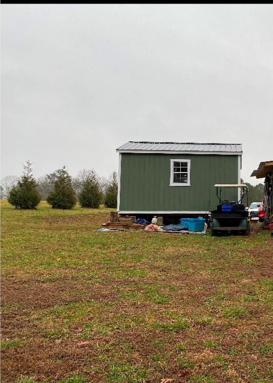 view of property exterior featuring an outbuilding and a lawn