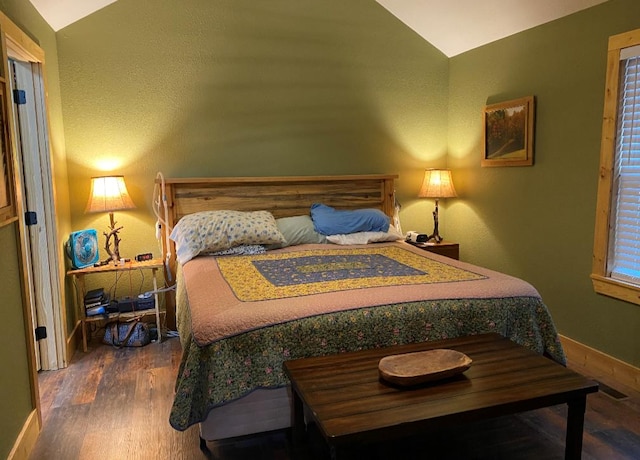 bedroom with vaulted ceiling and dark hardwood / wood-style floors