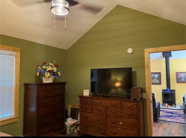 bedroom featuring vaulted ceiling and a wood stove