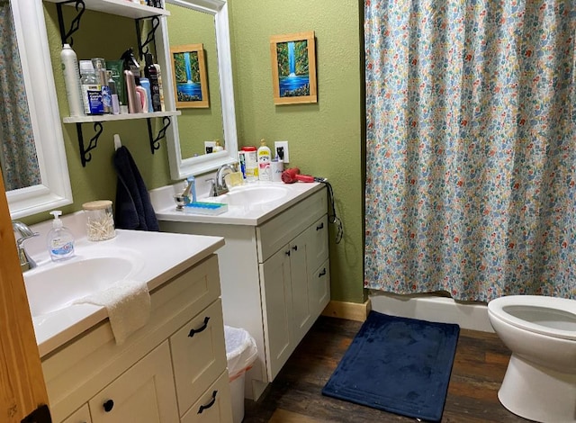 bathroom featuring hardwood / wood-style flooring, vanity, toilet, and curtained shower