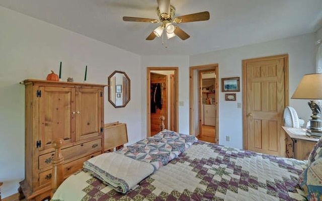 bedroom featuring ceiling fan, a closet, a walk in closet, and independent washer and dryer