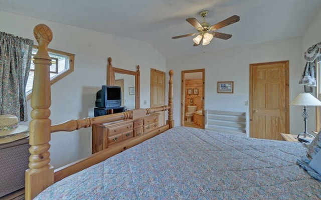 bedroom with ceiling fan, lofted ceiling, and connected bathroom