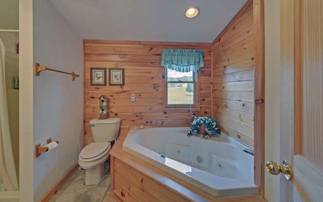 bathroom featuring toilet, wooden walls, and a bath