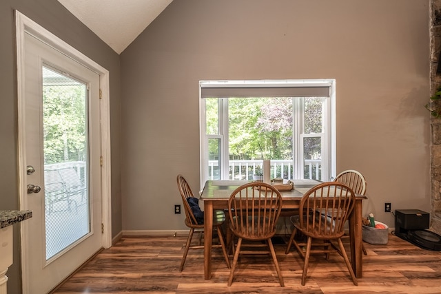 dining room with vaulted ceiling, wood finished floors, and a wealth of natural light