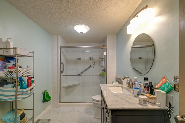 bathroom with baseboards, toilet, a stall shower, a textured ceiling, and vanity