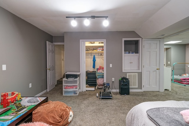 bedroom with visible vents, baseboards, carpet flooring, rail lighting, and a closet